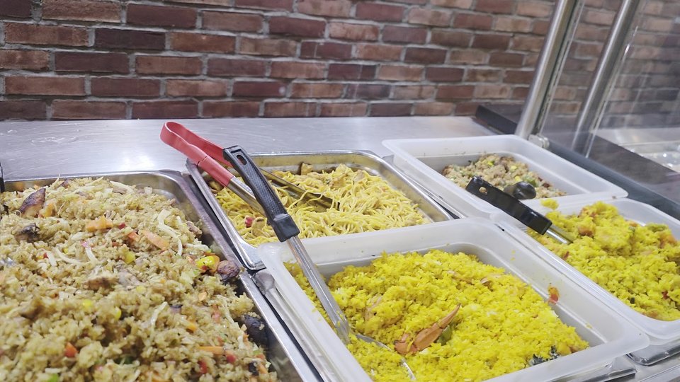 Jerk chicken served beside colorful sides.